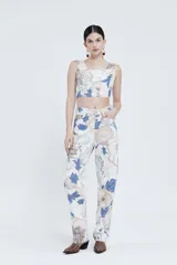 Pantalón de tiro alto y piernas amplias, confeccionado en gabardina de algodón estampada con diseño floral en tonos azul, beige y marrón.