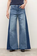 Jean wide leg bicolor en tonos de gris oscuro, con paneles laterales más oscuros y ruedo deshilachado.