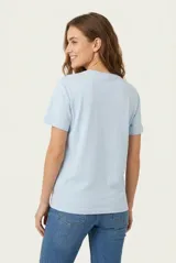 Remera de manga corta color beige, confeccionada en 100% algodón, con cuello redondo y estampa frontal con texto en tonos rosados.