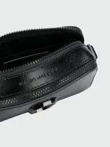 Cartera tipo crossbody de diseño rectangular, color negro, con cierre superior y logo metálico frontal. Incluye correa ajustable con diseño de marca.