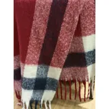 Bufanda rectangular de tejido grueso con diseño de cuadros en tonos azul, naranja, gris y beige, terminada con flecos en los extremos.