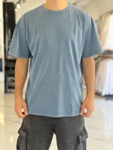 Remera de manga corta con efecto gastado o acid wash en color celeste, con corte oversize y cuello redondo.