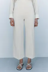 Pantalón tipo culotte de tiro alto, pierna ancha y pinzas frontales. Color beige/topo liso.