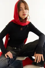 Top de manga larga con cuello alto, confeccionado en tejido de lycra y algodón. Presenta costuras a contratono, bordado central en el pecho, aberturas laterales en el ruedo y diseño con dedal en las mangas.