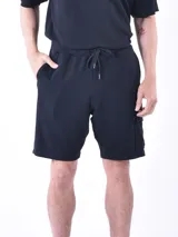 Bermuda negra de tejido texturizado con cintura elástica ajustable con cordón y bolsillo lateral tipo cargo.