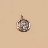 Medalla circular de plata 925 con relieve de San Cristóbal cargando al niño Jesús, con acabado pulido en los bordes y oxidado en el centro.