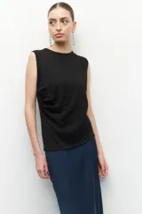 Musculosa negra sin mangas, de cuello redondo y con frunces laterales.