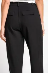 Pantalón negro de algodón peinado, corte recto y tiro medio, con pinzas delanteras y bolsillos laterales.