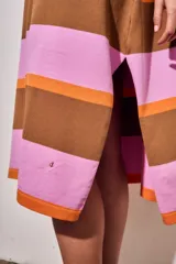 Vestido midi de tejido de punto con diseño de rayas horizontales en tonos rosa, naranja y marrón. Presenta cuello redondo, mangas cortas y un corte holgado con aberturas laterales en el ruedo.