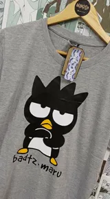 Remera gris con estampado de Badtz Maru, personaje de Sanrio.