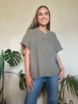 Chaleco tejido color verde oliva, con cuello en v y diseño de trenzas y ochos. Silueta oversize.