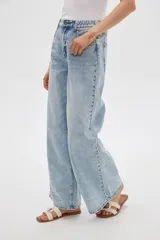 Pantalón jean de corte ancho y tiro alto, con lavado claro y cintura elástica posterior. Presenta bolsillos clásicos y presillas para cinturón.