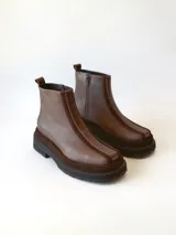 Bota corta de cuero en tonos chocolate, con diseño de paneles texturizados y suela track robusta de goma.