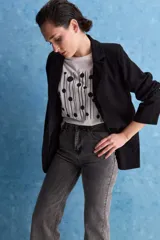 Jean de tiro alto con corte recto, confeccionado en denim con spandex. Presenta un lavado gris oscuro con efecto desgastado, cierre frontal con botón y bolsillos laterales y traseros.