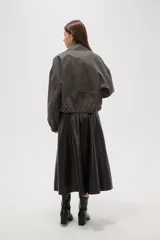 Campera de estilo utilitario en color gris oscuro con efecto lavado, confeccionada en poliéster. Presenta cuello camisero, cierre frontal con cremallera, bolsillos frontales con solapa y puños elásticos.