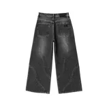 Pantalón de jean estilo ultra baggy, color negro con efecto lavado. Presenta un diseño de corte amplio con costuras curvas decorativas en el frente y bolsillos laterales.
