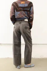 Jean de corte recto y largo, de tiro medio, color gris oscuro con efecto lavado. Presenta un bordado de estrella en los bolsillos traseros.