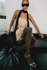 Vestido corto de estilo lencero, color rosado, con escote redondo, tirantes finos ajustables, bajo acabado en volante y detalles de encaje combinado a tono.