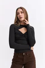 Top de manga larga confeccionado en licra satinada, con diseño ajustado al cuerpo. Presenta un escote con recortes estratégicos y detalles drapeados en el frente que aportan un toque sofisticado.