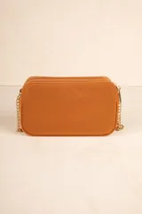 Bandolera negra con diseño acolchado en forma de zigzag, correa de cadena plateada y correa de cuero sintético ajustable.