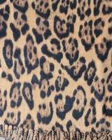 Bufanda de gran tamaño con estampado animal print en tonos negro y beige, con terminación de flecos en los extremos.