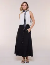 Falda midi evasé de algodón color negro, con tiro alto, pretina con elástico posterior, abotonadura frontal con botones carey y bolsillos laterales.