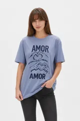 Remera de algodón negro con cuello redondo y diseño holgado, con estampado frontal de líneas horizontales blancas y un corazón rojo superpuesto.