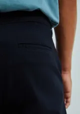 Pantalón de vestir color verde oscuro, de corte slim, con bolsillos laterales y traseros. Se ajusta a la cintura con botón y cierre.