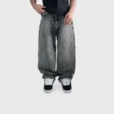 Pantalón de jean tipo baggy con corte oversize y efecto de lavado ácido en color gris oscuro. Presenta un diseño de pierna ancha y tiro medio.
