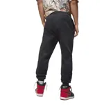 Pantalon de jogging Nike Jordan, confeccionado en tejido fleece color negro, con cintura elástica ajustable mediante cordón, puños elásticos en los tobillos y logo Jumpman bordado en color rojo en la pierna izquierda.