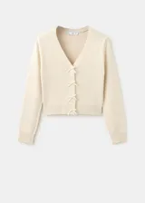 Cardigan de punto color beige, con escote en V y cierre frontal de botones con lazos decorativos.