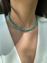 Collar corto con cuentas de cristal de murano color celeste y mostacillas amarillas. Se cierra con cadena de acero quirúrgico y ganchito para regular.