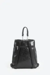 Mochila urbana de diseño bicolor en negro y marrón, confeccionada en material sintético con acabado brillante. Cuenta con un bolsillo frontal con cierre, asa superior trenzada y cierre principal con broche metálico.