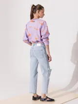 Jeans recto de tiro medio, color celeste claro, con roturas en las rodillas.
