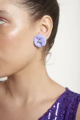 Aros en forma de flor de color lila, con centro decorado con pedrería brillante.