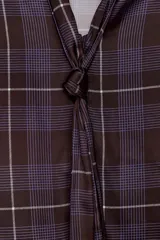 Camisa de tejido satinado con estampado de cuadros en tonos marrones y violetas. Presenta escote en pico con lazo integrado, mangas largas abullonadas y puños ajustados.