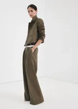 Pantalón de lino verde militar, de diseño recto y tiro alto, con detalle de pinzas y trabillas en la cintura.