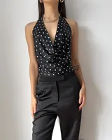 Top de satén con estampado de lunares, cuello drapeado y diseño halter con espalda descubierta.