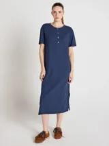 Vestido largo azul marino de corte recto y silueta relajada, con escote redondo, mangas cortas y cierre frontal parcial de botones. Cuenta con aberturas laterales en el bajo.