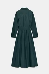 Vestido midi de estilo camisero color bordó, con cuello solapa, escote en pico y cierre frontal con botones ocultos. Presenta manga larga, bolsillos laterales ocultos, solapas decorativas en el pecho y cinturón de lazada en el mismo tejido.