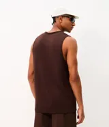 Musculosa deportiva marrón con cuello redondo, confeccionada con tecnología Dry y tejido de modal, poliéster y elastano. Presenta una pequeña estampa minimalista en el pecho.