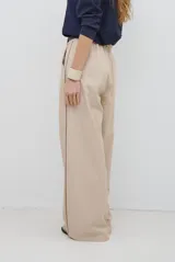 Pantalon de corte recto y pierna ancha, confeccionado en tejido tipo denim oscuro. Presenta tiro alto, cintura con cierre frontal y bolsillos laterales funcionales.