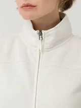 Chaleco de micropolar color blanco hueso, con cuello alto, cierre frontal completo y dos bolsillos laterales con cierre.