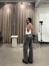 Pantalón de jean gris con efecto lavado, de corte recto y tiro bajo. Presenta costuras verticales decorativas en el frente y bolsillos tipo cargo frontales.