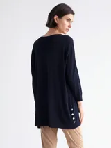 Sweater largo azul marino de tejido de punto, con cuello redondo, mangas 3/4, bolsillo lateral y botones decorativos en el ruedo.