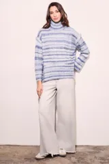 Polera celeste con rayas horizontales en tonos de azul y blanco, de cuello alto y corte oversize.