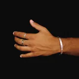 Anillo plateado con diseño de tres bandas entrelazadas, una lisa y dos con textura escamada.