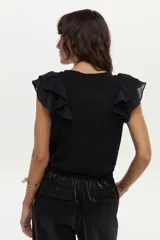 Blusa blanca vaporosa con volados en los hombros y cuello redondo.