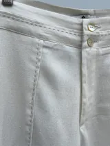 Pantalón de lino y viscosa color crudo, con cierre de botón y tiro alto.