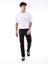 Pantalón de vestir negro, de corte recto, con bolsillos laterales y traseros. Se ajusta a la cintura con cinturón de cuero marrón.